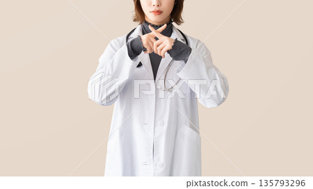 A female medical staff member making an X pose with her fingers A female medical staff member making an X pose with her fingers 135793296