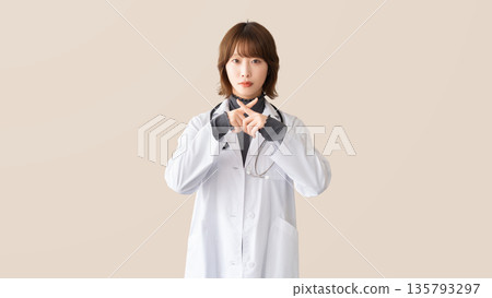 一名女性醫護人員用手指擺出「X」型姿勢 一名女性醫護人員用手指擺出「X」型姿勢 135793297