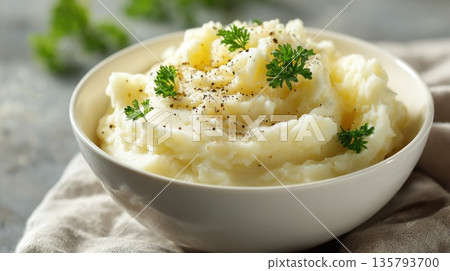 Creamy mashed potatoes served in a white bowl with fresh parsley and black pepper Creamy mashed potatoes served in a white bowl with fresh parsley and black pepper 135793700