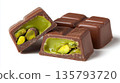 Dark chocolate pieces revealing vibrant pistachio filling 135793720