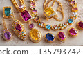 Luxury gold jewelry with colorful gemstones displayed on marble 135793742