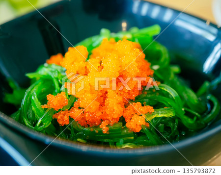 Seaweed salad topped with shrimp roe or flying fish roe (tobiko). Japanese food. Seaweed salad topped with shrimp roe or flying fish roe (tobiko). Japanese food. 135793872