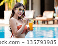 Sexy young asian woman in swimsuits in summer. beautiful woman in orange bikini with sunglasses and tropical drink sitting in swimming pool. 135793985