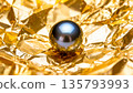 Chrome steel sphere on a textured gold foil background. 135793993