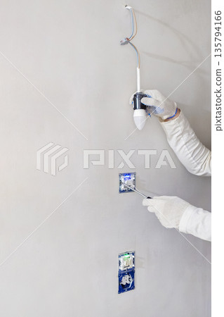 A person is fixing a light fixture A person is fixing a light fixture 135794166