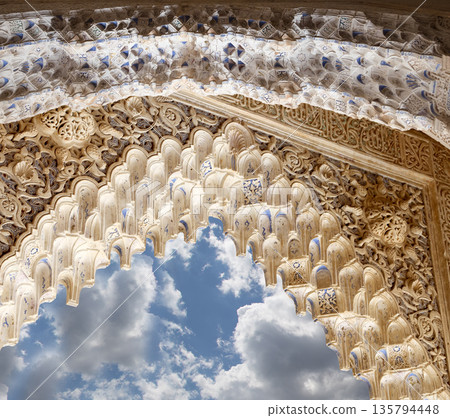 Arches in Islamic (Moorish)  style (against the background of a beautiful sky with clouds) in Alhambra, Granada, Spain 135794448
