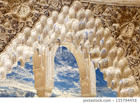 Arches in Islamic (Moorish)  style (against the background of a beautiful sky with clouds) in Alhambra, Granada, Spain 135794458