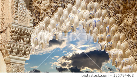 Arches in Islamic (Moorish) style (against the background of a beautiful sky with clouds) in Alhambra, Granada, Spain Arches in Islamic (Moorish) style (against the background of a beautiful sky with clouds) in Alhambra, Granada, Spain 135794468