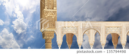 Arches in Islamic (Moorish) style (against the background of a beautiful sky with clouds) in Alhambra, Granada, Spain 135794498