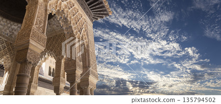 Arches in Islamic (Moorish) style (against the background of a beautiful sky with clouds) in Alhambra, Granada, Spain 135794502