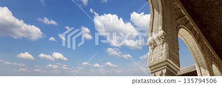 Arches in Islamic (Moorish) style (against the background of a beautiful sky with clouds) in Alhambra, Granada, Spain 135794506