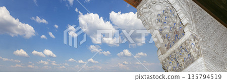 Arches in Islamic (Moorish) style (against the background of a beautiful sky with clouds) in Alhambra, Granada, Spain Arches in Islamic (Moorish) style (against the background of a beautiful sky with clouds) in Alhambra, Granada, Spain 135794519