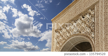 Arches in Islamic (Moorish) style (against the background of a beautiful sky with clouds) in Alhambra, Granada, Spain 135794520