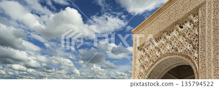 Arches in Islamic (Moorish) style (against the background of a beautiful sky with clouds) in Alhambra, Granada, Spain 135794522