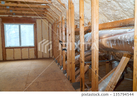 Workers prepare attic by installing wooden frames insulation to finish construction. Workers prepare attic by installing wooden frames insulation to finish construction. 135794544