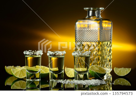 Gold tequila with sea salt and lime slices. 135794573