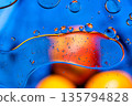 Macro abstract of oil bubbles on blue liquid with warm orange highlights. 135794828