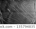 Gray plastic film texture with diagonal folds, neutral industrial background. 135794835