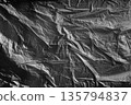 Deep black crumpled plastic texture with strong folds, dramatic backdrop for modern compositions. 135794837