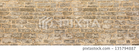 Old gray stone wall texture background presenting rough masonry pattern Old gray stone wall texture background presenting rough masonry pattern 135794887