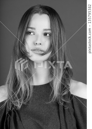 Young woman looking away in black and white studio portrait Young woman looking away in black and white studio portrait 135795382