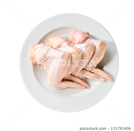raw chicken wings on a plate isolated on a white background, top view. raw chicken wings on a plate isolated on a white background, top view. 135795406
