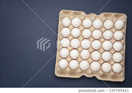 Easter Eggs in carton box, minimal style composition on dark blue background. Easter Eggs in carton box, minimal style composition on dark blue background. 135795421