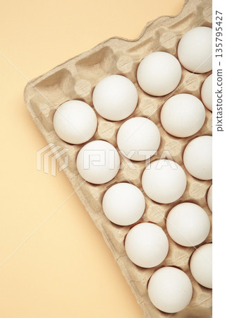 Easter Eggs in carton box, minimal style composition on beige background. Vertical photo Easter Eggs in carton box, minimal style composition on beige background. Vertical photo 135795427