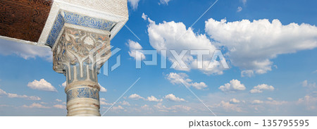 Columns in Islamic (Moorish)  style in Alhambra (against the background of a beautiful sky with clouds), Granada, Spain 135795595