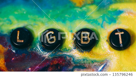 Lgbt word. Glitter ink. Defocused yellow blue purple color sparkling letters tolerance splatter pride particle black texture on abstract art background. Lgbt word. Glitter ink. Defocused yellow blue purple color sparkling letters tolerance splatter pride particle black texture on abstract art background. 135796246