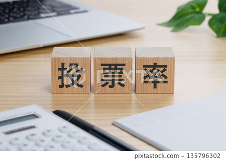 A block with the word "voter turnout" written on it on the table 135796302