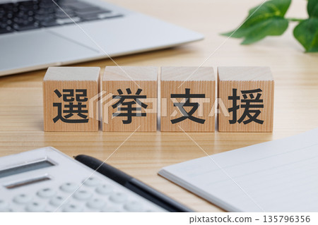 A block with the words "election support" written on it on the table 135796356