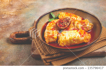 Stuffed cabbage rolls with minced meat, in tomato sauce, top view, without people, in the spotlight. 135796417