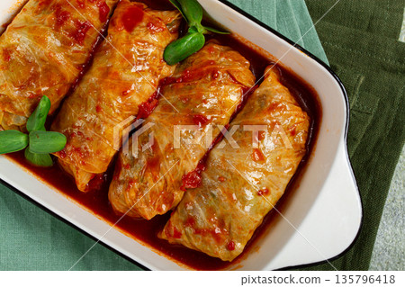 Stuffed cabbage rolls with minced meat, in tomato sauce, top view, without people, in the spotlight. Stuffed cabbage rolls with minced meat, in tomato sauce, top view, without people, in the spotlight. 135796418
