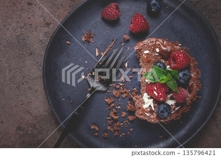 half-eaten chocolate tartlet, on a plate, stuffed with cottage cheese and berries, breakfast, homemade, no people, half-eaten chocolate tartlet, on a plate, stuffed with cottage cheese and berries, breakfast, homemade, no people, 135796421