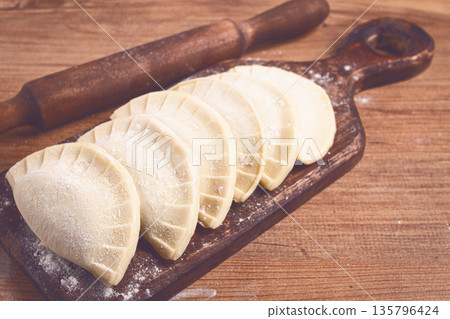 raw chebureks, mini, on a cutting board, wooden table, close-up, no people, raw chebureks, mini, on a cutting board, wooden table, close-up, no people, 135796424