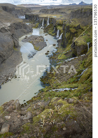 Vertical shot of river valley with multiple waterfalls streaming into it, Highlands, Iceland Vertical shot of river valley with multiple waterfalls streaming into it, Highlands, Iceland 135796530
