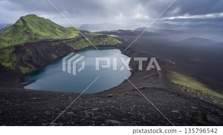 Vast volcanic landscape with mountains and craters with cars travelling through, Highlands, Iceland 135796542