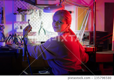 Woman artisan crafting jewelry in her creative workshop 135796580