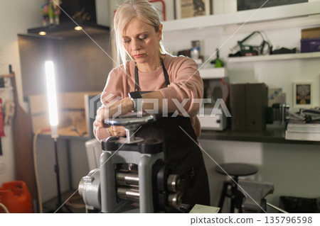 Woman working rolling mill machine crafting metal 135796598