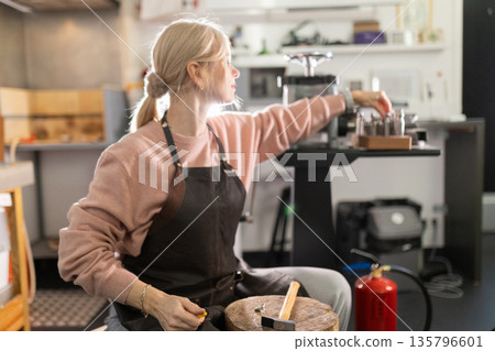 Female artisan handcrafting jewelry in workshop studio Female artisan handcrafting jewelry in workshop studio 135796601