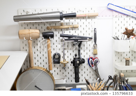 Jewelry making workshop tools hanging on pegboard 135796633