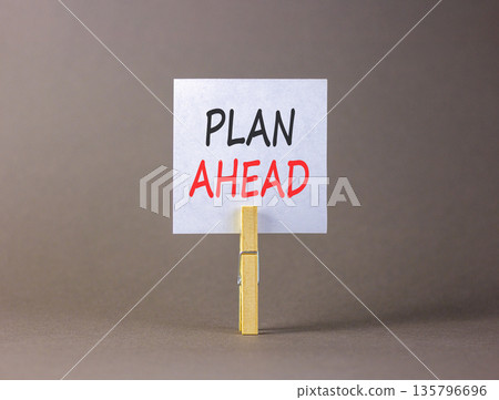 Plan ahead symbol. Concept word Plan ahead on beautiful white paper. Beautiful wooden clothespin. Beautiful grey background. Business plan ahead concept. Copy space. Plan ahead symbol. Concept word Plan ahead on beautiful white paper. Beautiful wooden clothespin. Beautiful grey background. Business plan ahead concept. Copy space. 135796696