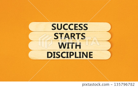 Success starts with discipline symbol. Concept words Success starts with discipline on beautiful wooden sticks. Beautiful orange background. Business success starts with discipline concept. Copy space 135796782