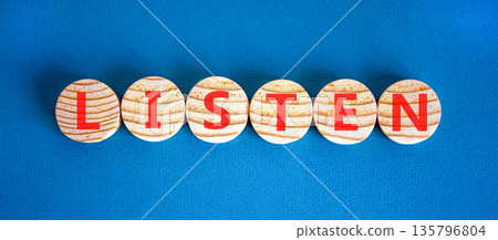 Listen symbol. Concept word Listen on beautiful wooden circles. Beautiful blue background. Business education listen concept. Copy space. Listen symbol. Concept word Listen on beautiful wooden circles. Beautiful blue background. Business education listen concept. Copy space. 135796804