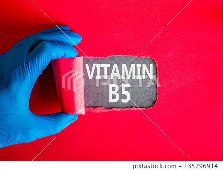 Vitamin B5 pantothenic acid symbol. Concept words Vitamin B5 on beautiful grey paper. Doctor hand in blue medical glove. Beautiful red background. Medical healthy lifestyle Vitamin B5 concept. 135796914