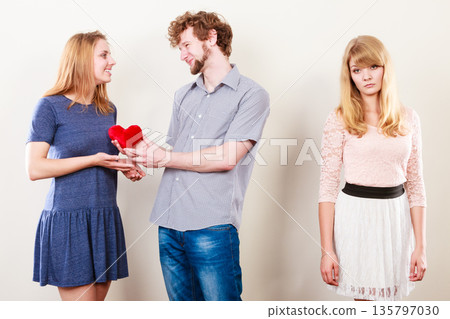 Abandoned woman with enamored couple 135797030