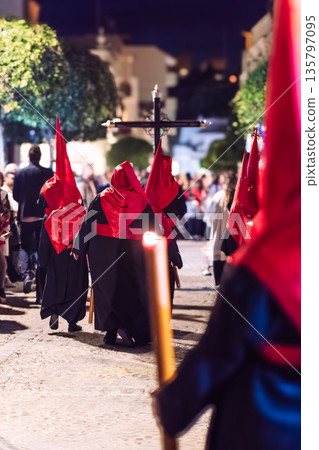Back view of nazarenos walking in a holy week procession 135797095