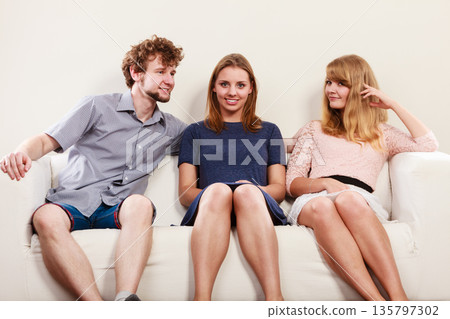 Happy friends sitting on sofa. Happy friends sitting on sofa. 135797302