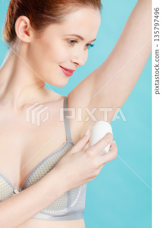 Girl applying stick deodorant in armpit Girl applying stick deodorant in armpit 135797496